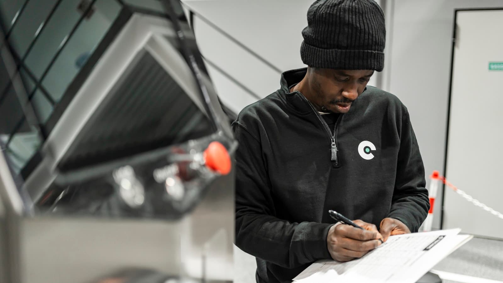 A worker completing check-in paperwork at an industrial facility
